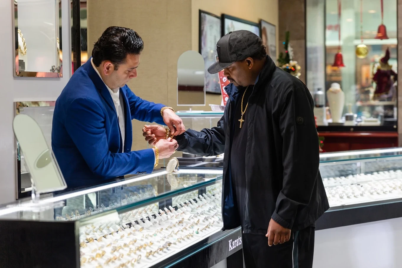 A Karats Jewelry specialist fitting a bracelet for a customer at the counter