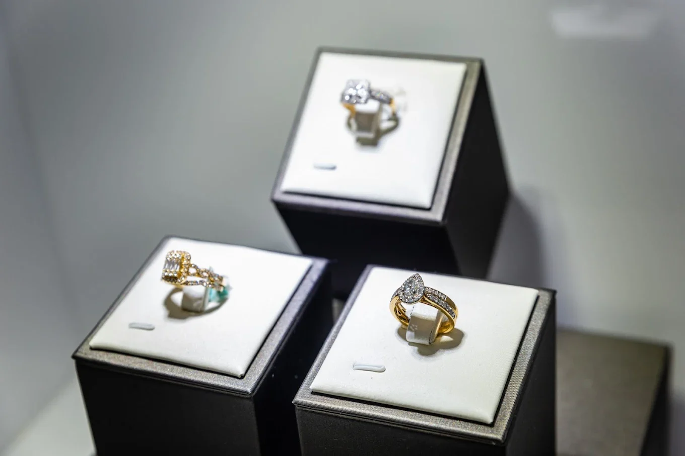 Three diamond halo rings presented on black ring boxes