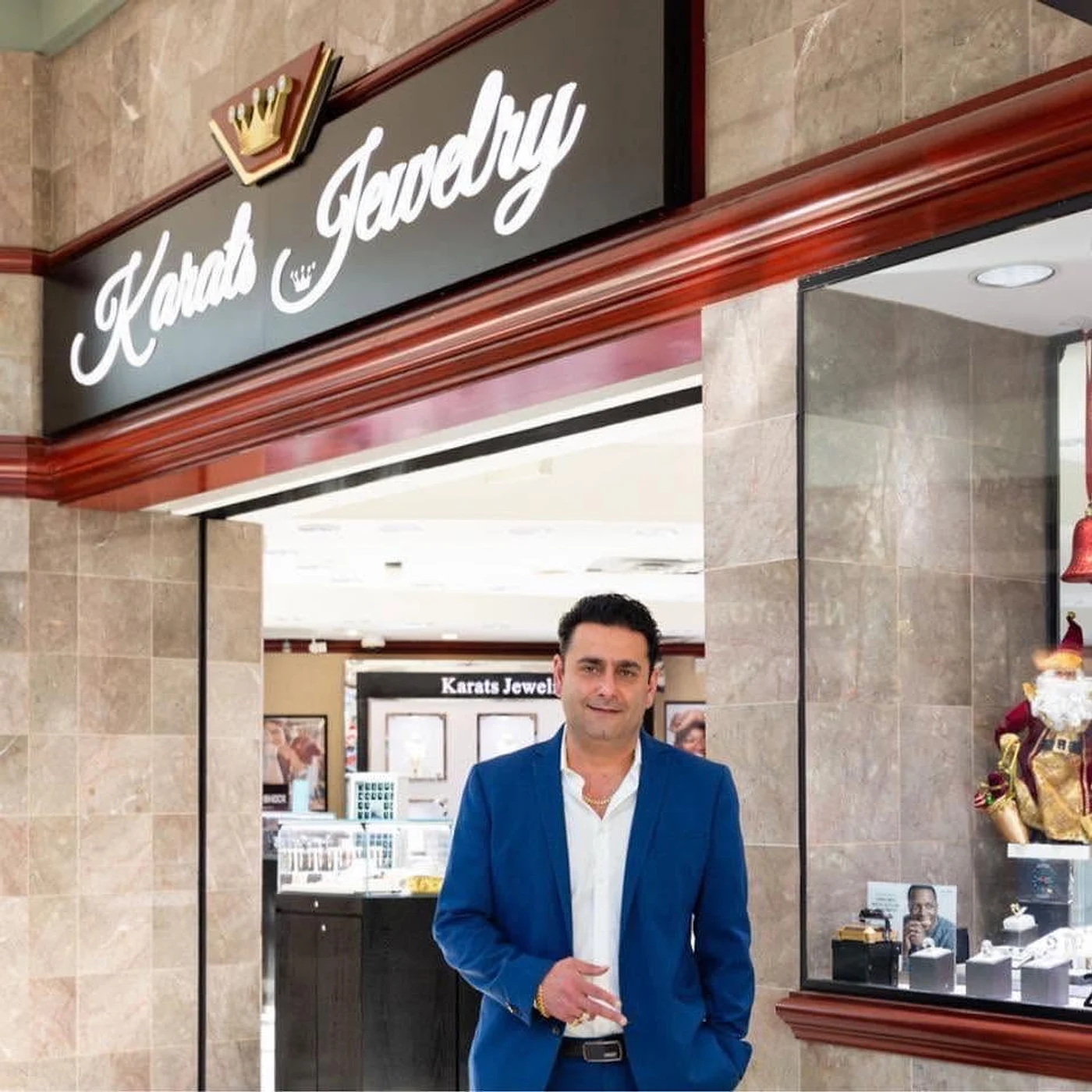 Karats Jewelry owner standing at the showroom entrance under the store sign