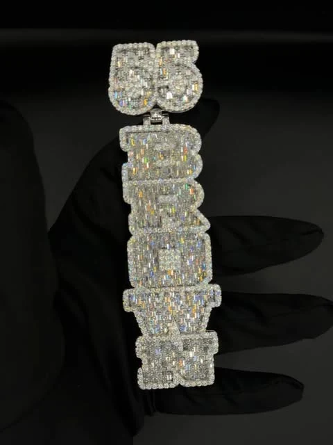 Iced-out diamond letter pendant against a black background